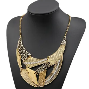 Close-up detail of geometric patchwork statement necklace, vintage gold finish with rhinestone.