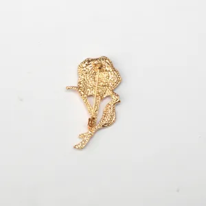 Detailed back view of the golden carnation flower brooch showing pin clasp and textured metal.