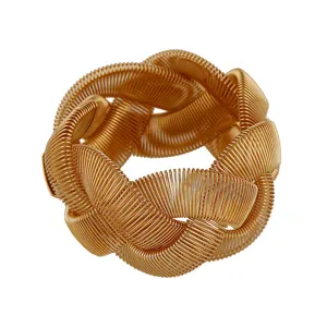 Detailed close-up of a chunky gold wire woven cuff bracelet, featuring a bold metallic texture.