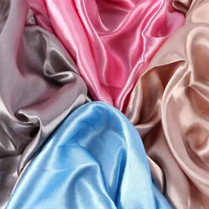 Primo piano di tessuto satinato colorato che mostra consistenza liscia e lucentezza brillante.