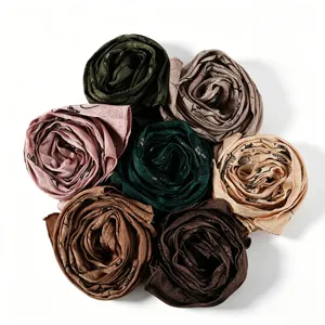 Detailed close-up view of colorful imitation silk printed leaf long scarves rolled neatly into flowers.