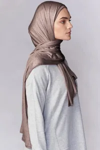 Vista detallada del hiyab de modal brillante adornado con pedrería llevado por una modelo.