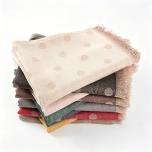 Detailed close-up of metallic jacquard polka dot rayon scarf with fringe texture details.