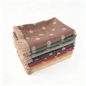Stacked metallic polka dot scarves showcasing colorful fabric texture and fringe detail.