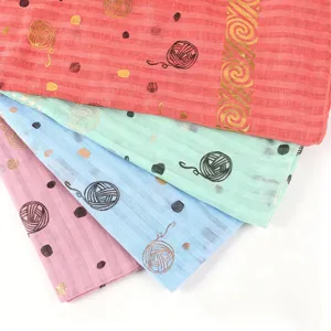 Gros plan sur le foulard imprimé léger avec motif de fil en feuille d'or, tissu multicolore.