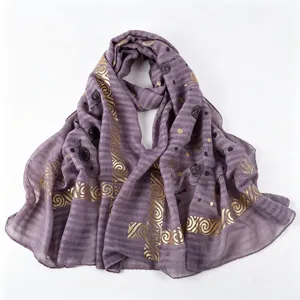Foulard hijab violet léger avec des motifs dorés brillants, vue de détail très élégante.
