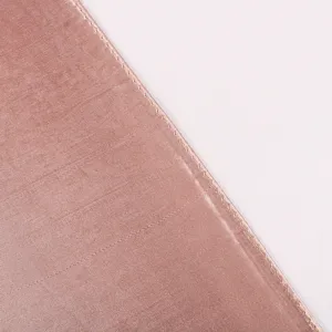 Primo piano dettagliato del bordo di una sciarpa in seta satinata rosa con cuciture fini.