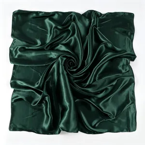 Sciarpa quadrata in raso verde scuro con texture liscia e finitura lucida dettaglio.
