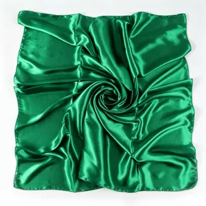 Dettaglio ravvicinato del foulard quadrato in raso verde con texture morbida e lucida.
