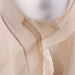 Vista dettagliata della sciarpa leggera in chiffon beige con trama e cuciture fini.