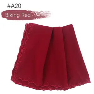 Gedetailleerd overzicht van de rode chiffon hoofddoek geborduurd met kanten randen, hijab.