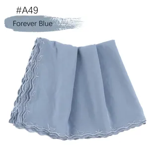 Gedetailleerd overzicht van de blauwe chiffon hoofddoek met fijn kanten borduurwerk en drape.