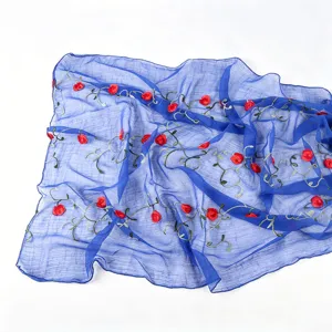 Detailed view of blue chiffon scarf featuring exquisite red floral embroidery and delicate green vines.