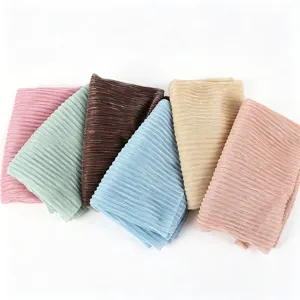 Detail view of colorful metallic pleated hijabs, showcasing delicate texture and fabric quality.