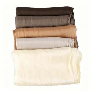 Detailed view of stacked smooth crinkle satin hijabs in elegant gradient neutral shades for women.