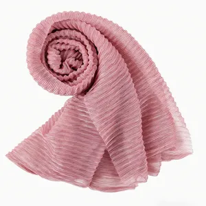 Close-up detail of the pink metallic pleated hijab scarf, showing fine texture and shimmer.