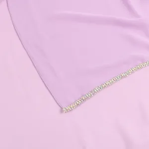 Detail view of a purple chiffon hijab featuring a sparkling rhinestone chain border for women.
