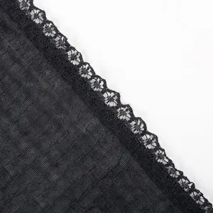 Close-up detail of black honeycomb crinkled lace scarf and head wrap, linen texture fabric.
