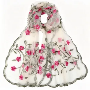 Close-up of a sheer nylon scarf with delicate embroidered green vines and pink flowers.