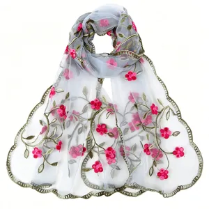 Delicate sheer scarf detail featuring intricate pink floral embroidery and gold vine trim.