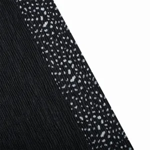 Detail of pleated long scarf with printed black border, soft breathable fabric for women.