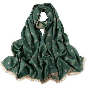 Detailed view of the dark green women long scarf shawl with gold polka dots and short fringe.