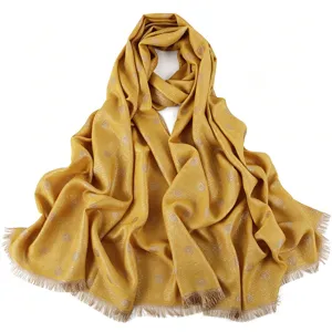 Gold glitter polka dot detail on yellow fabric of long scarf fringe edge close-up