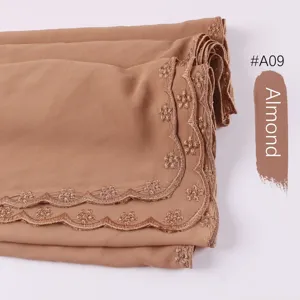 Vista detallada de bufanda hijab de gasa bordada con elegante borde de encaje ondulado.