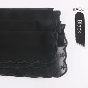 Detalle de bufanda de gasa bordada en negro, elegante hiyab con ribete floral de encaje.