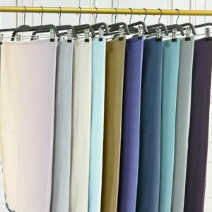 Vista dettagliata di foulard in chiffon multicolore appesi ordinatamente su clip nere.