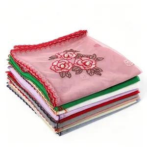 Close-up detail of embroidered floral mesh scarf with pearl accents and wavy lace edges.