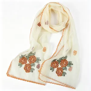 Close up detail of women embroidered mesh scarf with pearls and elegant orange scalloped edge.