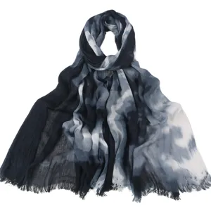 Detailopname van de gekreukte katoenen tie-dye sjaal met zachte textuur en wolkprint.