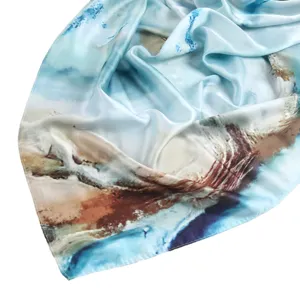 Close-up view of the blue abstract marble print silk scarf showing soft fabric and smooth drape.
