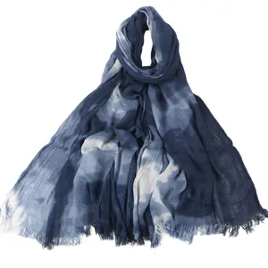 Close-up detail van blauwe tie-dye katoenen sjaal met geplooide textuur en zachte stof.