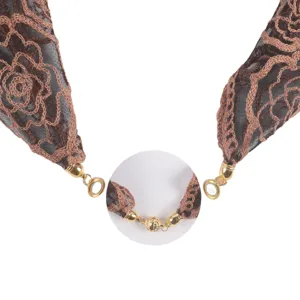 Bruine rozen kant hijab sjaal detail met elegante borduursel en luxe gouden magnetische sluiting.
