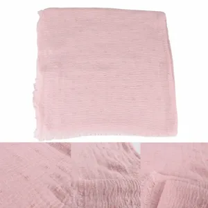 Pink crinkled cotton linen scarf lightweight breathable pompom raw edge shawl detail view.