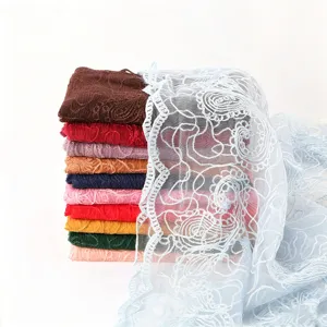 Detailed close-up of delicate floral embroidered lace scarf texture, lightweight and elegant.