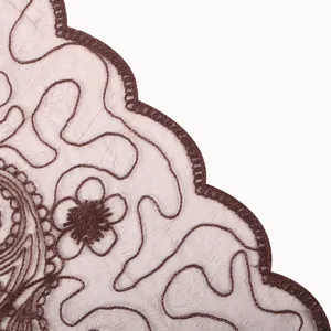 Close-up detail of sheer women scarf with delicate brown floral embroidery and scalloped edge.