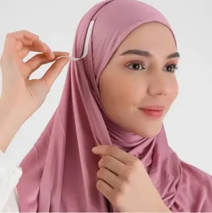 Vista dettagliata di hijab rosa con nastro adesivo bifacciale per una tenuta sicura.
