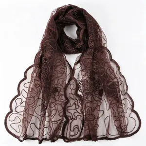 Close-up of brown sheer embroidered floral lace scarf detail, delicate mesh fabric edge.