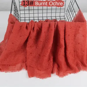 Solid color lightweight cotton linen scarf with crinkled raw edge detail in burnt ochre.