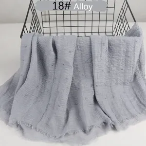 Solid color lightweight cotton linen scarf with crinkled pom-pom and raw edge details.
