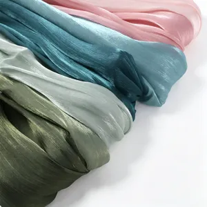 Detailopname van glanzende geplooide satijnen sjaals in diverse kleuren, zacht en soepel.