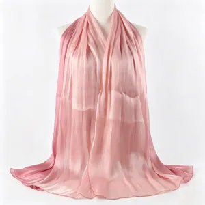 Detailopname van de roze glanzende satijnen sjaal met zachte kleurovergang en fijne plooitextuur.
