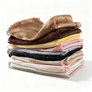 Detailed view of stacked luxury shimmer lace trimmed long scarves in assorted colors.