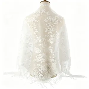 Detailed view of white lace triangular shawl with elegant floral rose pattern and delicate fringe.