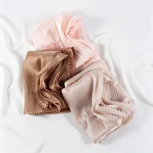 Detailed view of crinkled chiffon scarves with delicate embroidery and beaded lace edges.