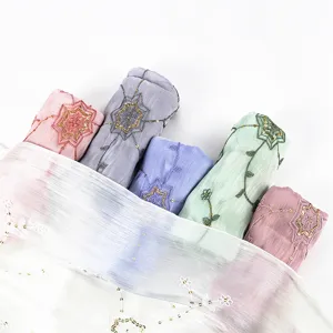 Vista dettagliata di un elegante foulard hijab ricamato con paillettes, tessuto leggero.