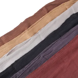 Primo piano dettagliato del tessuto per sciarpa in cotone plissé che mostra consistenza e colori.